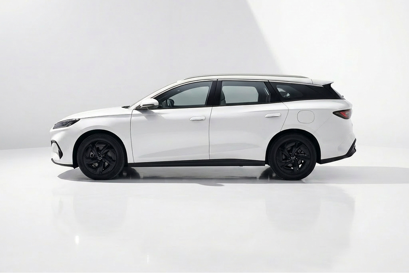 Side view of a sleek white modern station wagon with black wheels and tinted windows.