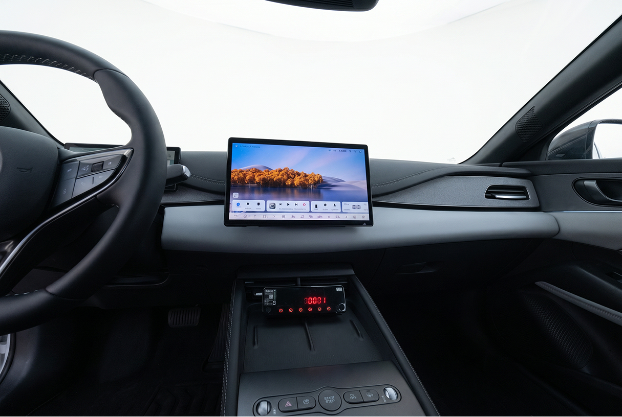Interior view of a car dashboard with digital touchscreen and steering wheel.