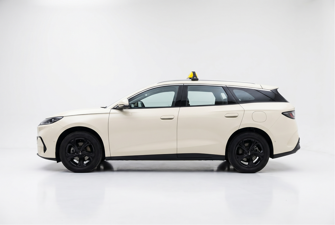 Side view of a white modern station wagon with black wheels and a small yellow-yellow-black object on the roof.