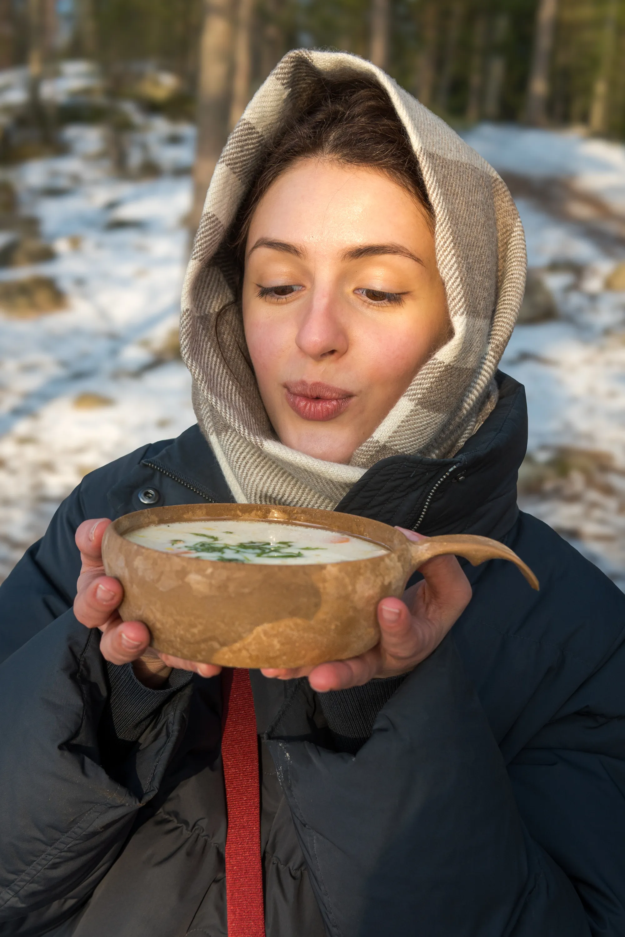 Guests cooking traditional Finnish salmon soup over an open fire