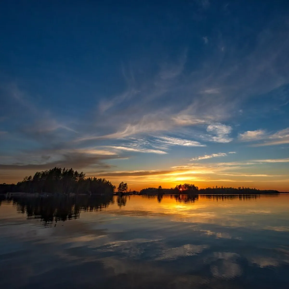 Sunset reflected on the still water of Lake Saimaa