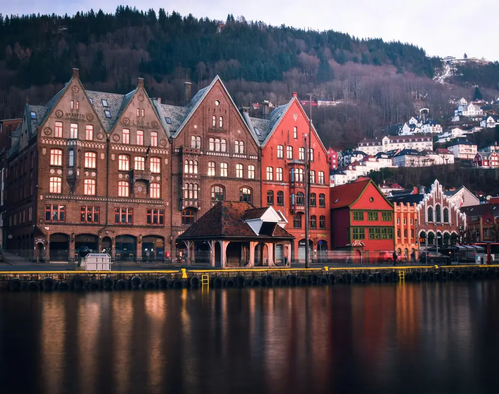 Historic Bryggen wharf reflected in Bergen harbour at dusk
