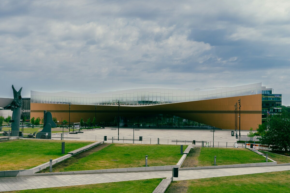 Oodi Central Library's curved timber façade beside a Helsinki lawn