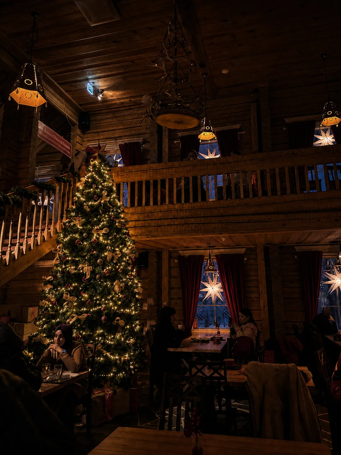 Christmas tree inside a warmly lit wooden Lapland lodge