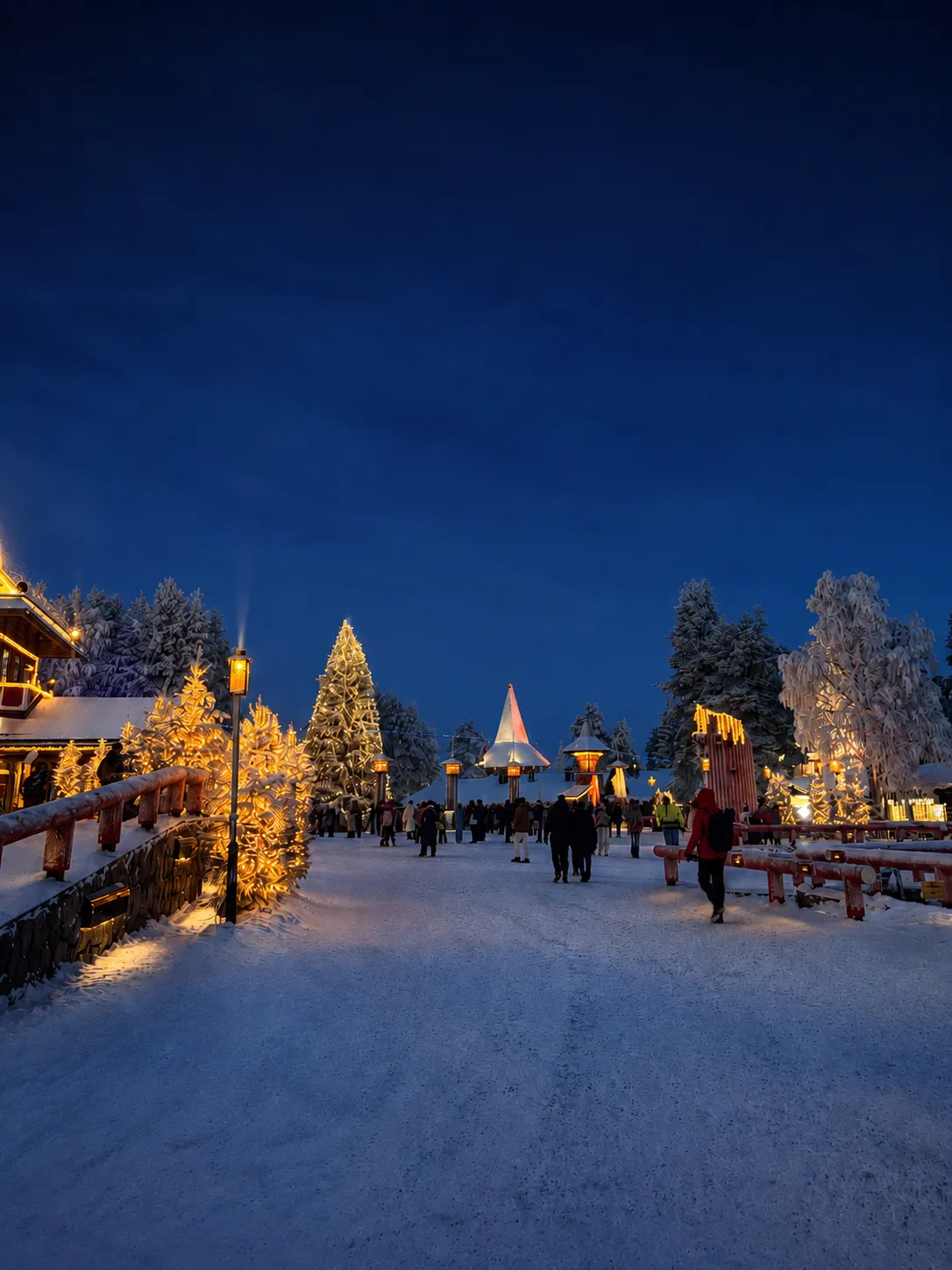 Visitors walking through an illuminated snowy village in Lapland