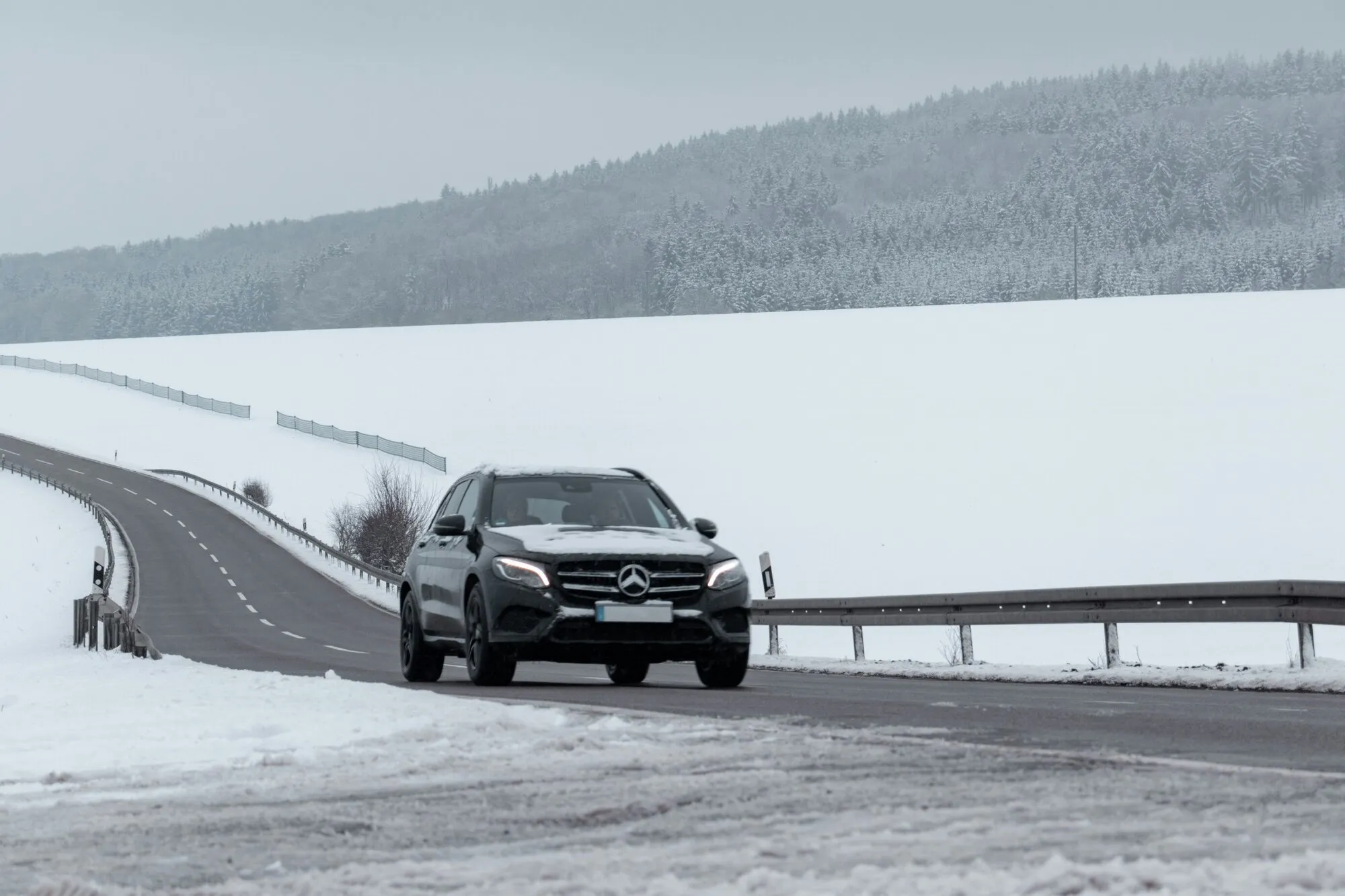 Vehicle driving along a snow-covered road in Lapland