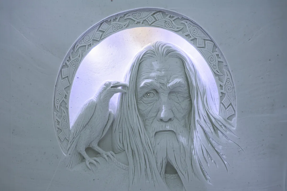 Illuminated face carved into a snow wall at Lainio SnowVillage