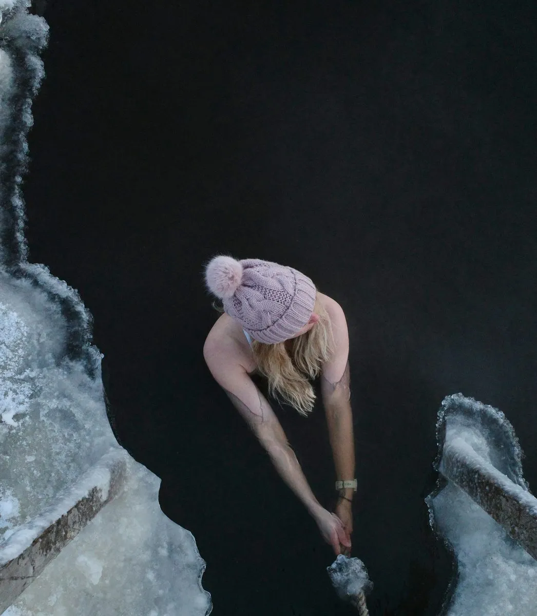 Winter ice plunge in open water surrounded by snow and ice in Finnish Lapland