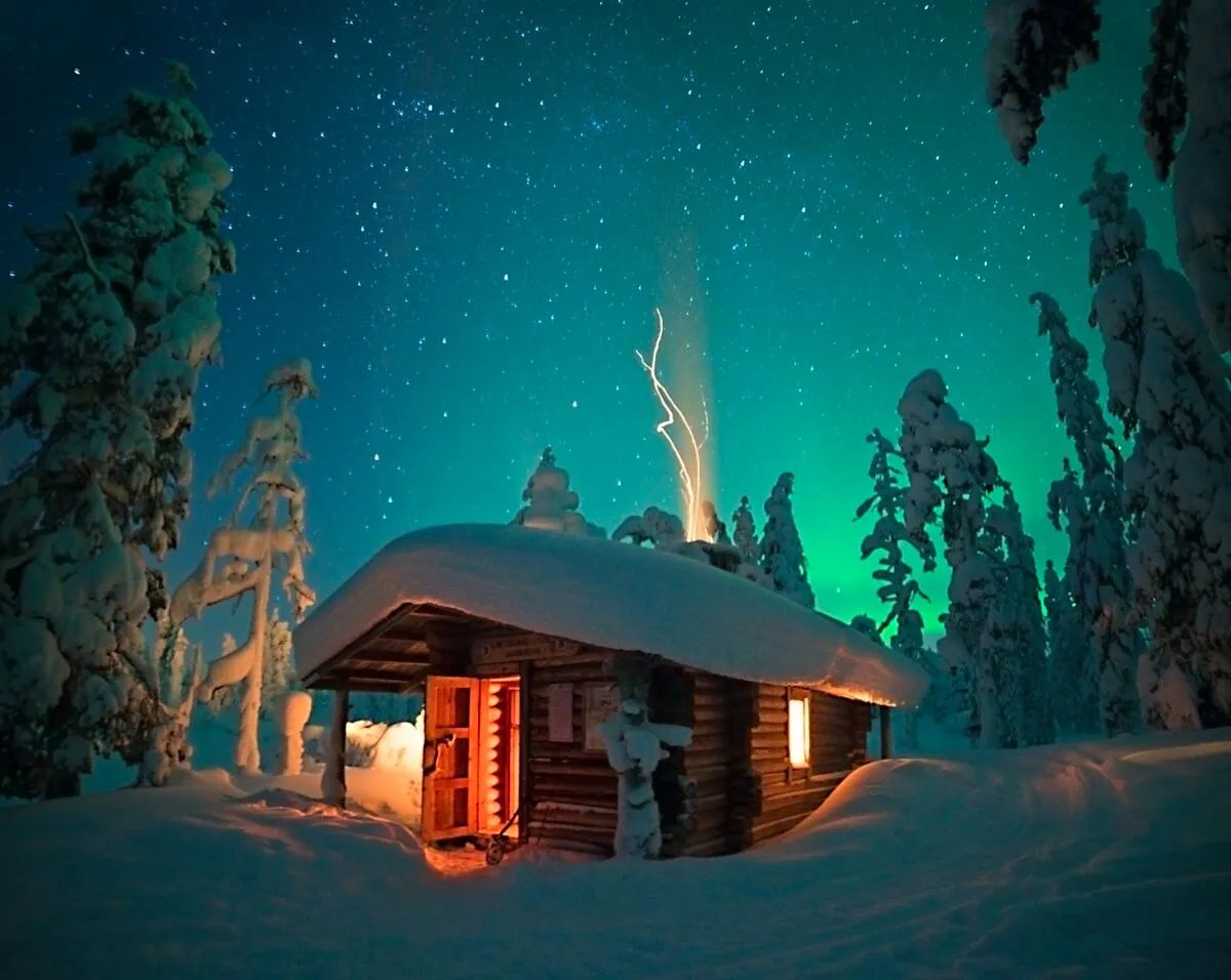 Snow-covered private cabin in Finnish Lapland at dusk