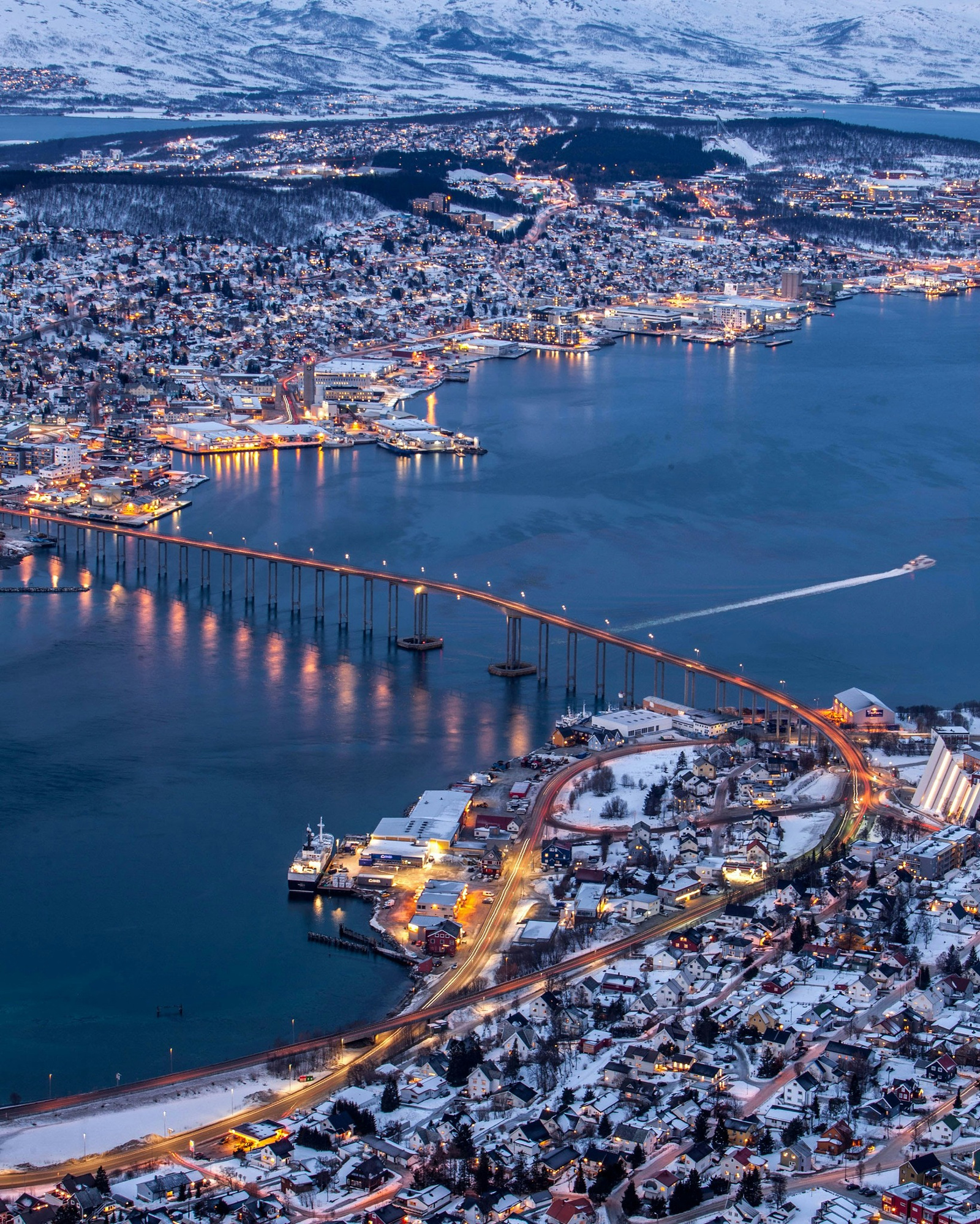 Tromsø and the Tromsø Bridge lit up at winter dusk
