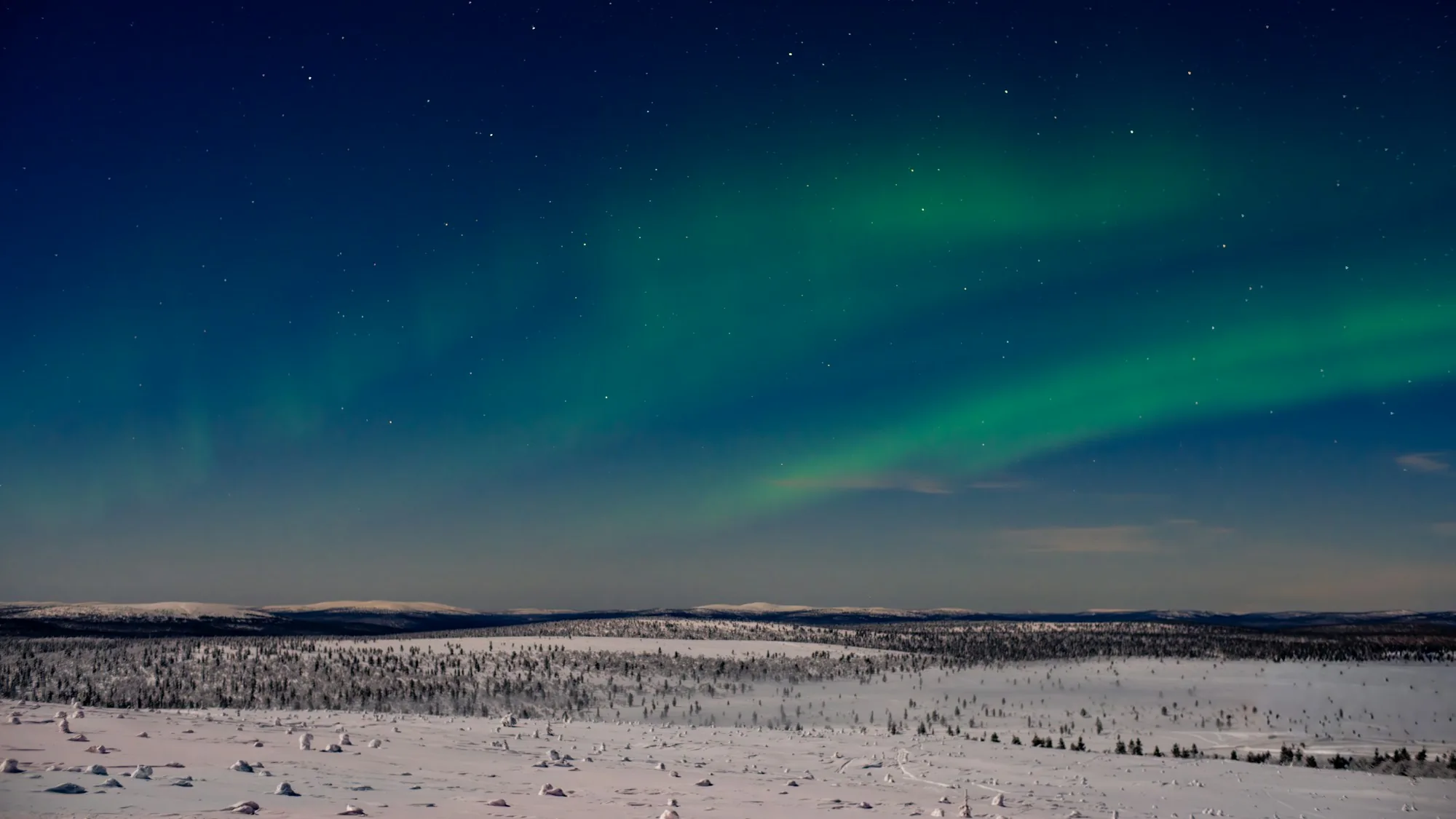 Green northern lights over the snowy fells around Saariselkä in Finnish Lapland