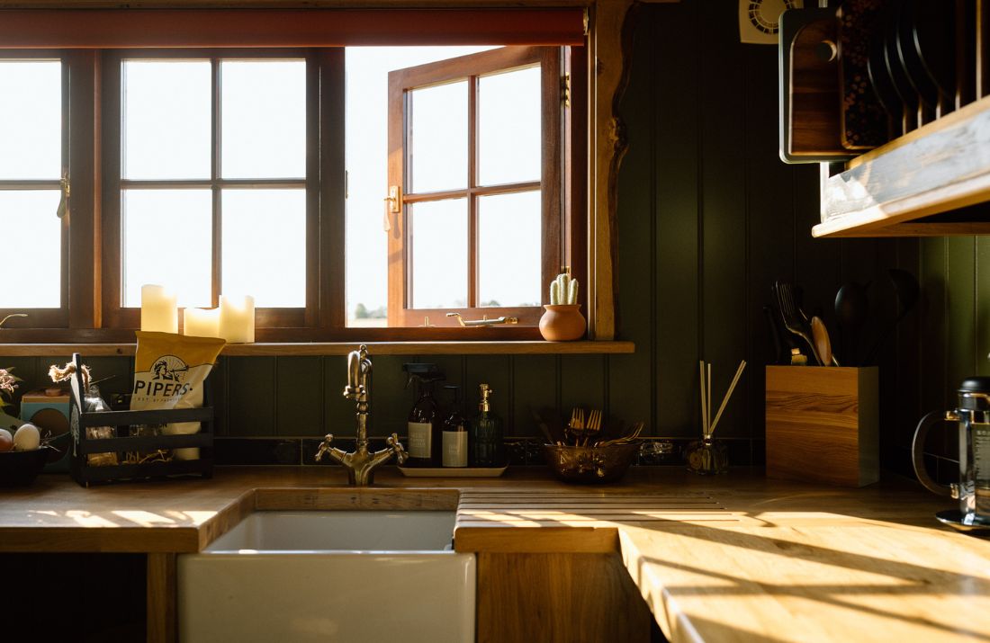 The kitchenette inside the shepherds hut, showing the Belfast sink and wooden worktops.