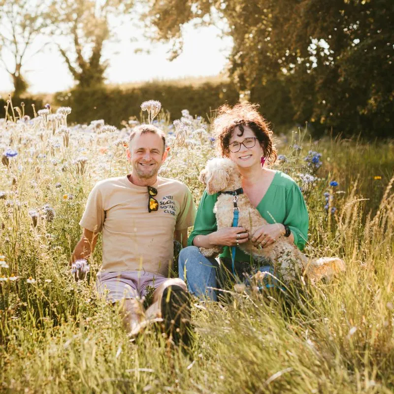 Cat and Alex, of Sycamore & Stars sat in the field with their dog