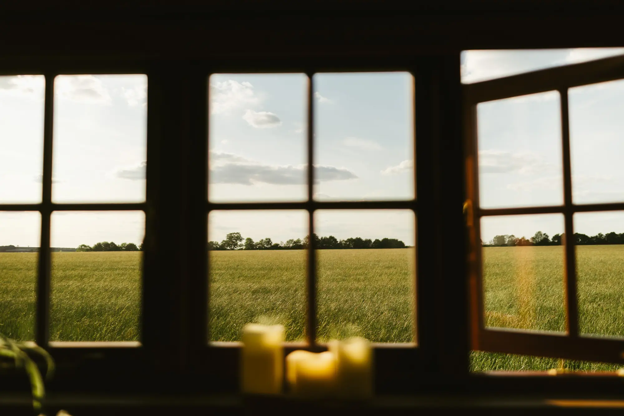 Open window looking out over the field at sunset