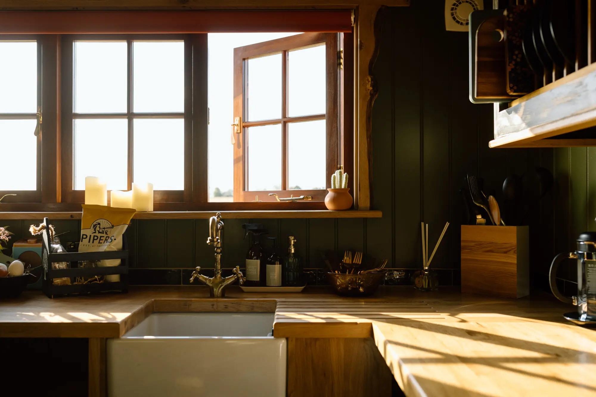 Kitchen with butler sink and brass tap, windows onto the fields