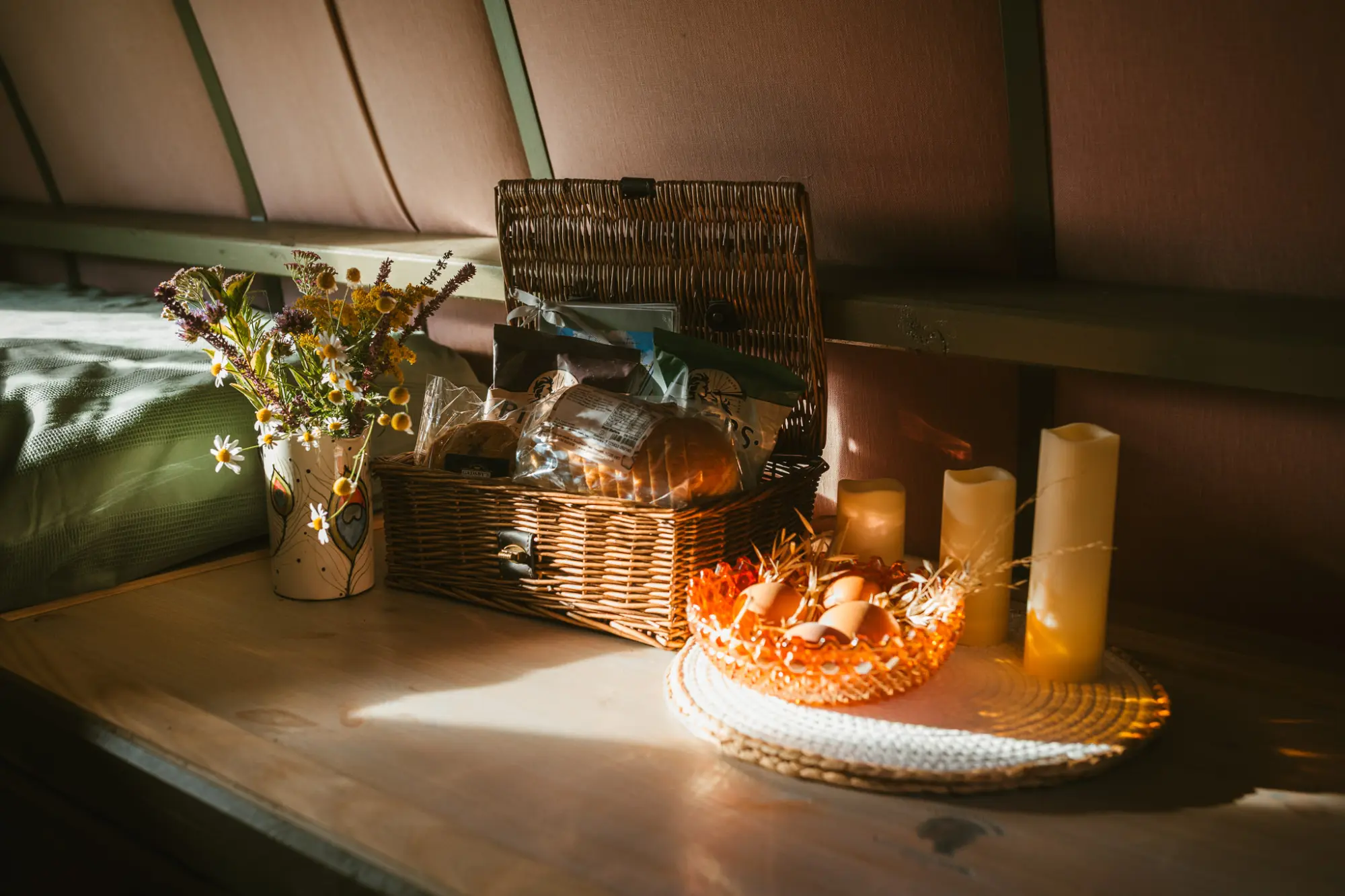 Welcome hamper with bread, eggs, wild flowers and candles