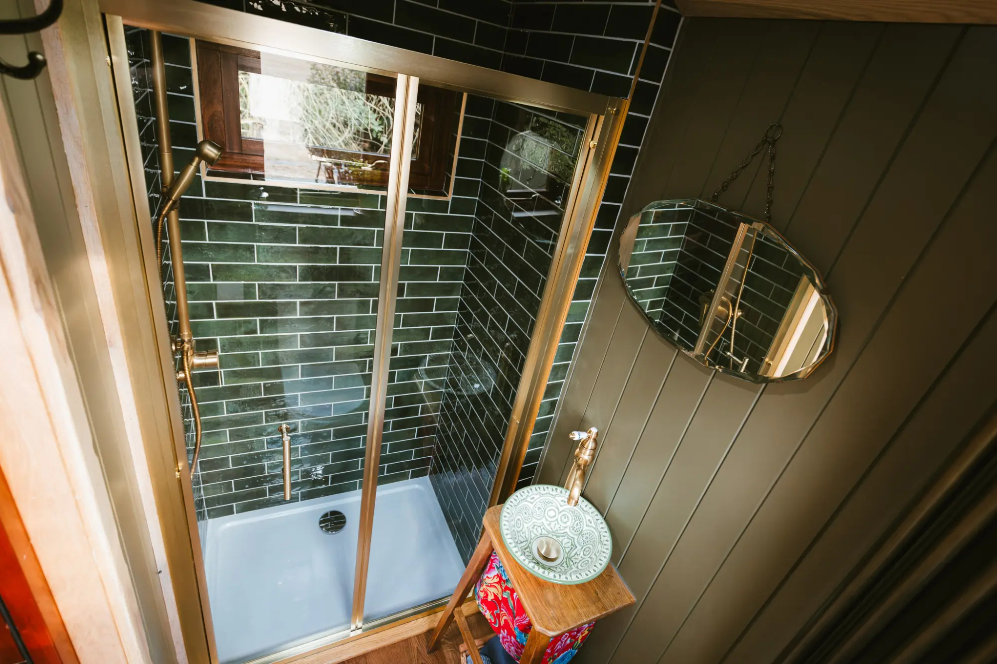 Shower room with dark green tiles and a patterned basin