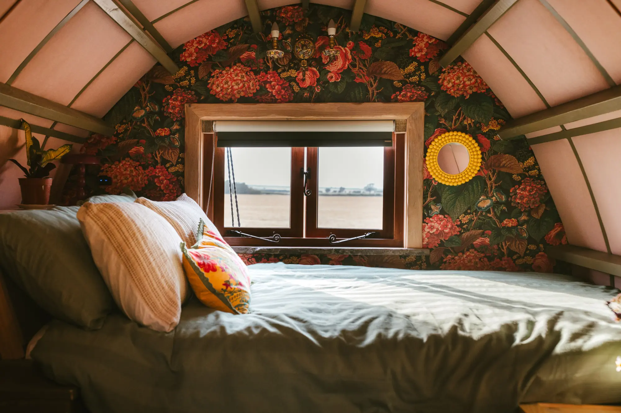 Double bed under the curved roof, looking out over fields