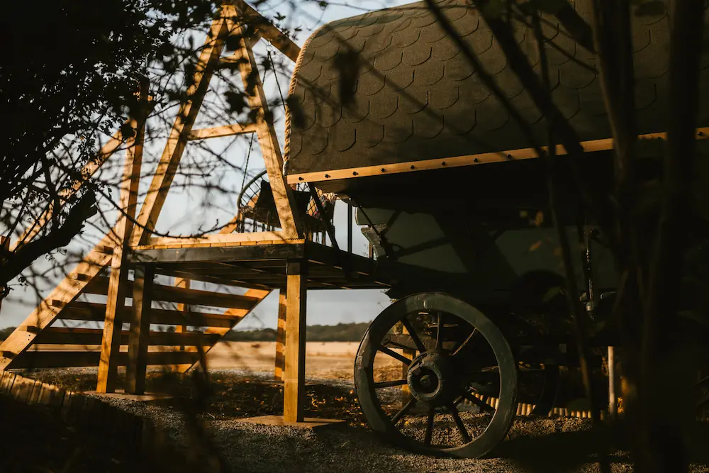 The Old Hay Cart, steps leading up to a covered rustic cart in a rural field.