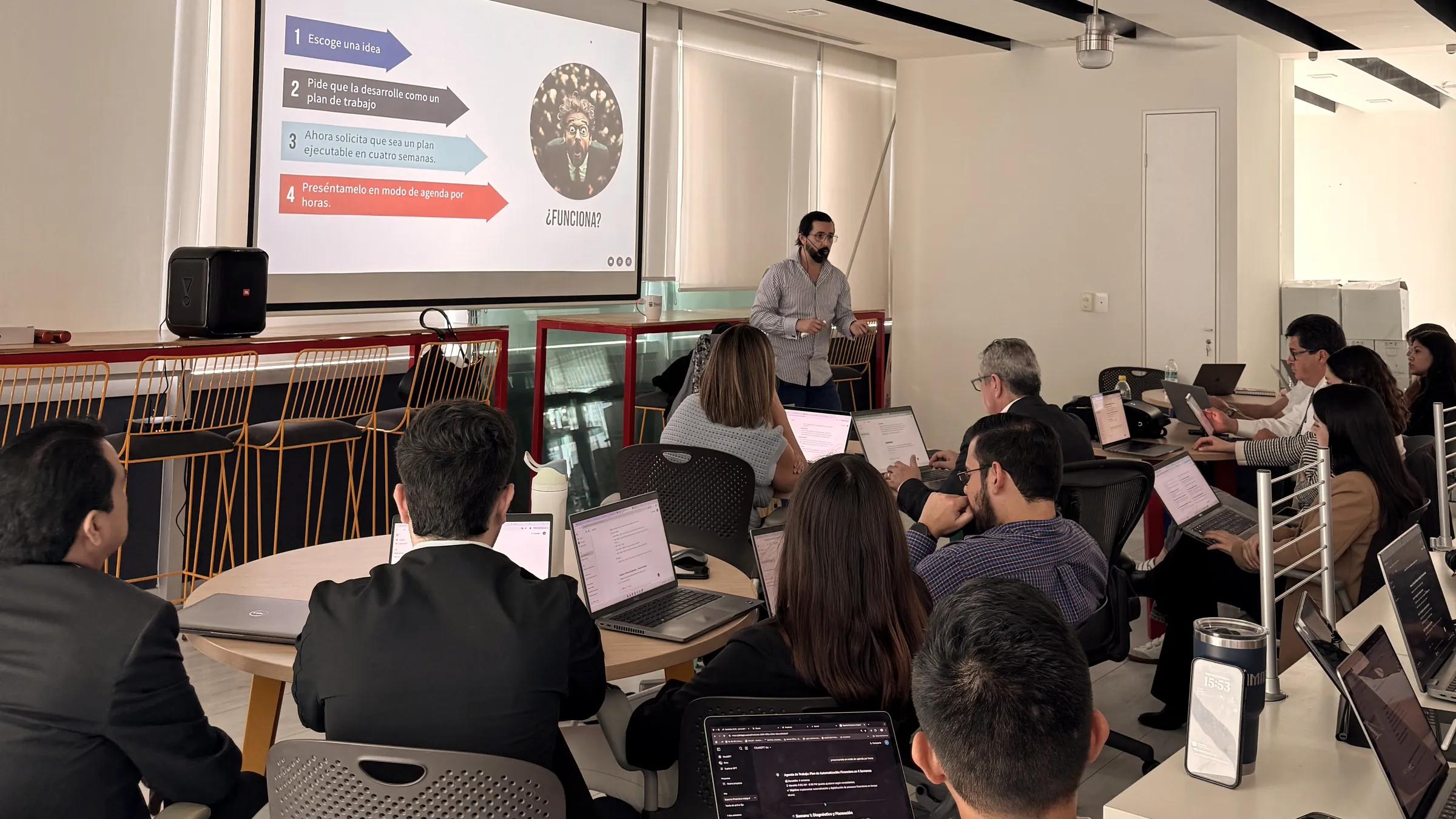Taller ejecutivo de IA de DANVILX: ejecutivos practicando con laptops mientras Daniel Villarreal guía la sesión