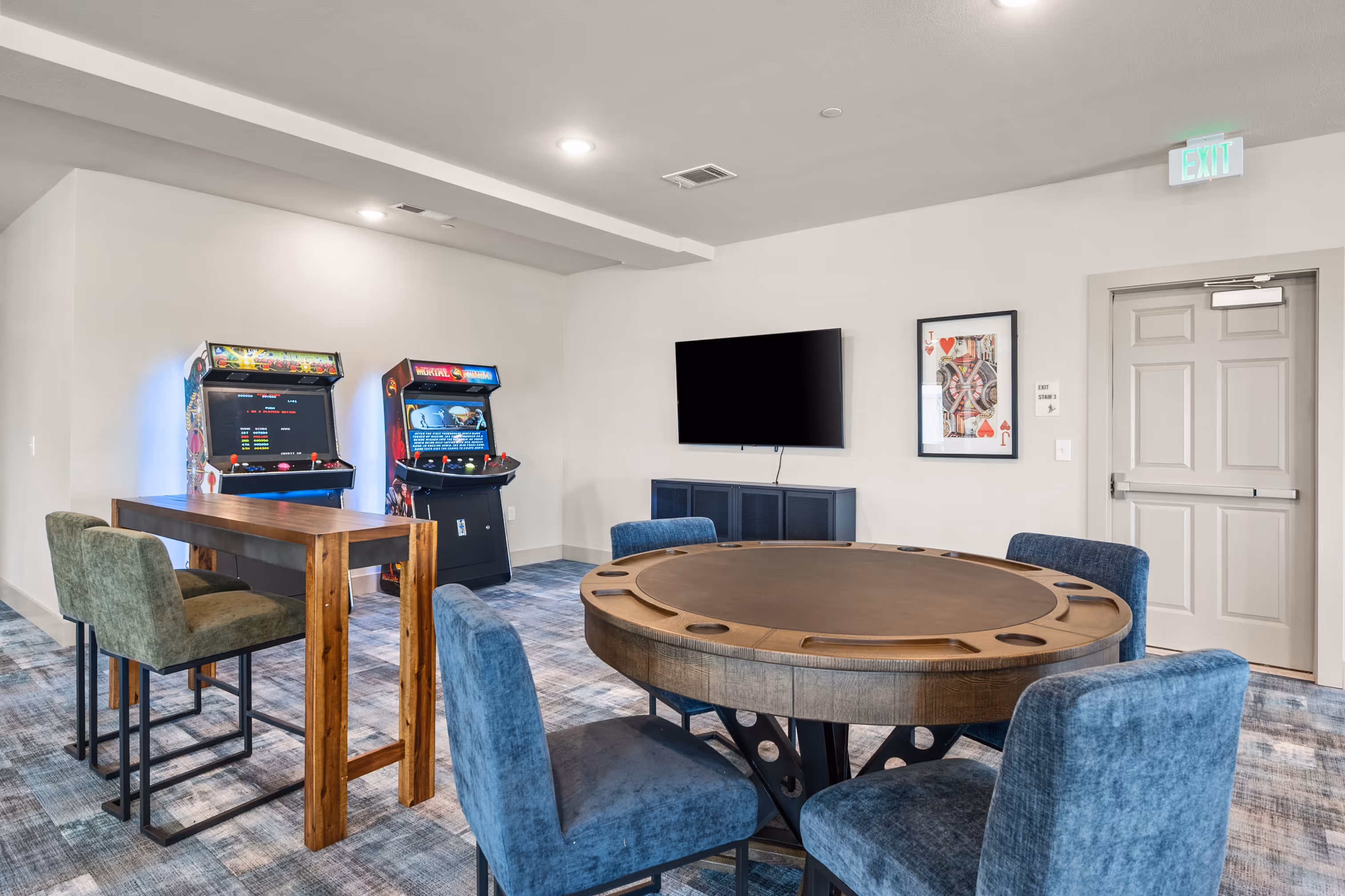 Game room with poker table, arcade games, and tv