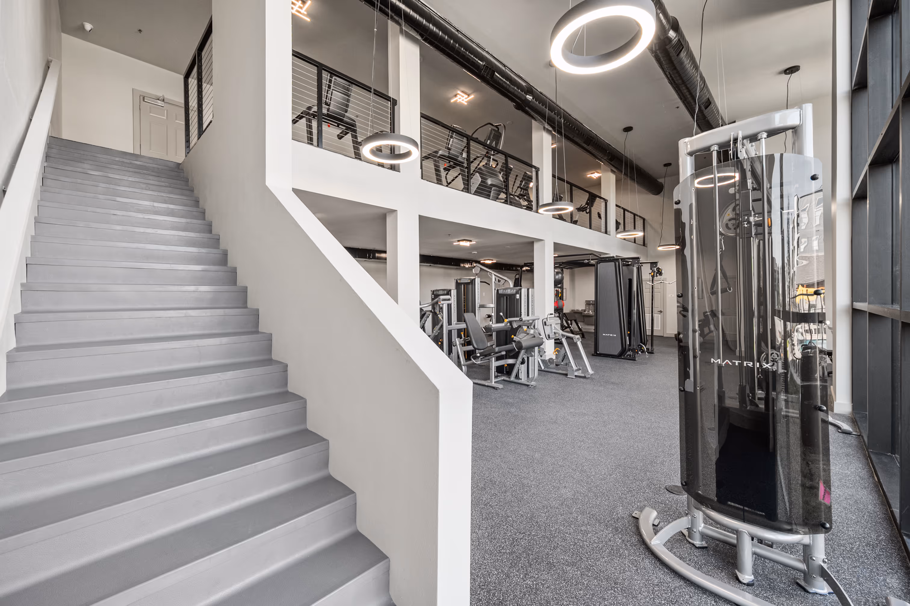 Gym with two floors featuring treadmills and weight machines