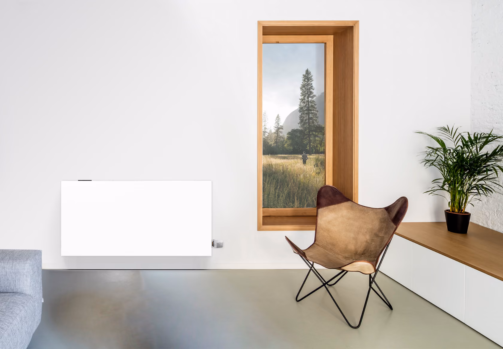 Moderne woonkamer met leren stoel, plant, houten raam en witte radiatorkachel aan de muur.