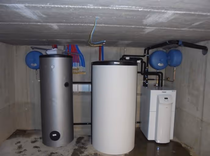 Technische ruimte met warmtepomp, boiler en buffervat in een bedrijfsgebouw