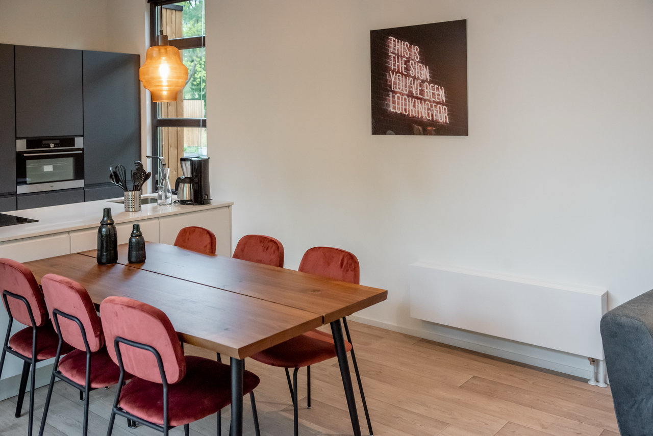 Eetkamer met een ventilo-convector aan de wand voor verwarming en koeling