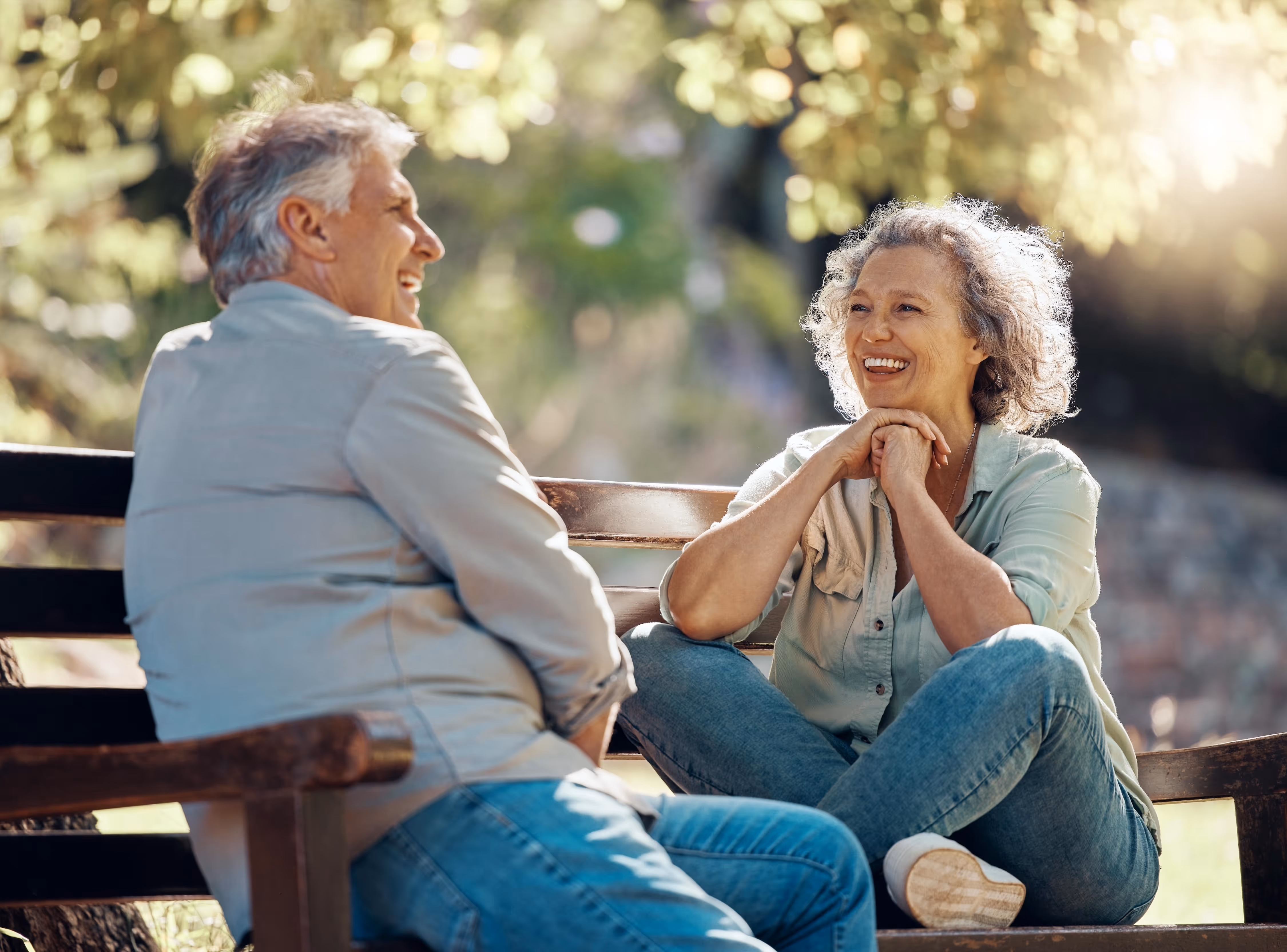 Two people sitting on the bench smiling at each other stock image