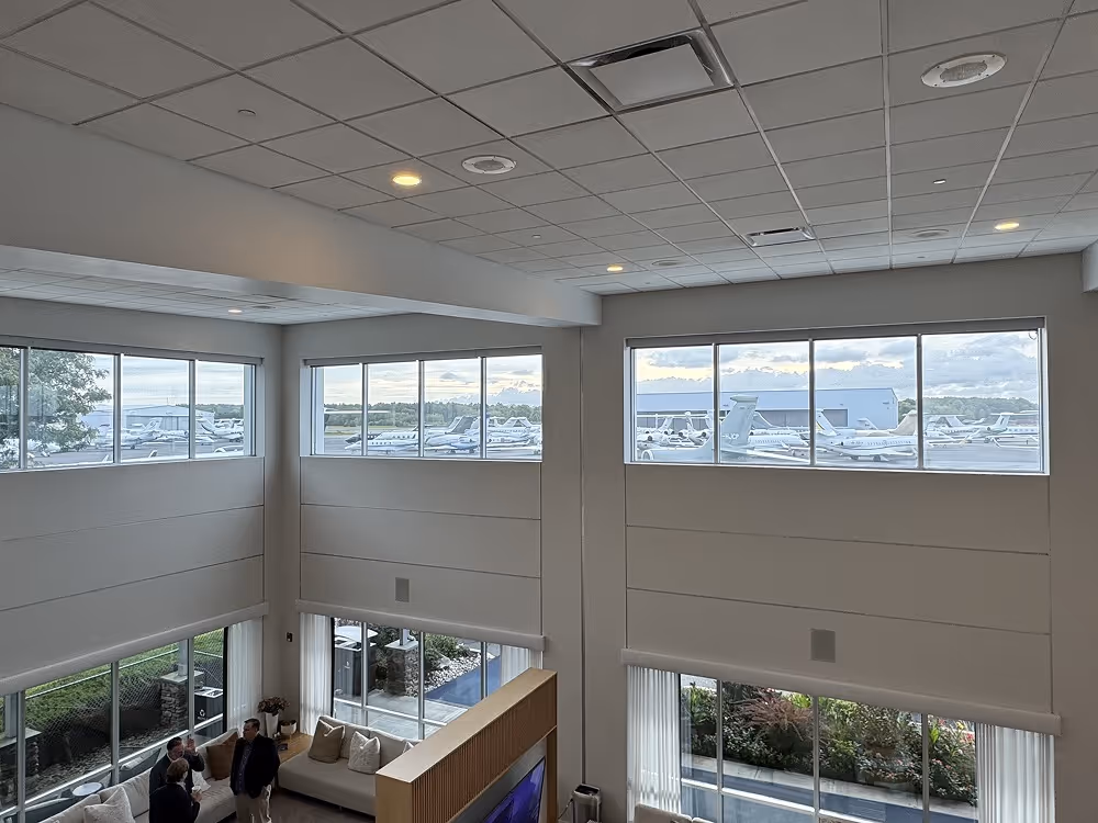 Interior view of an office with large windows showing parked planes outside at an airport.