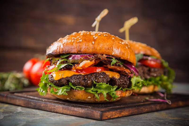 A close up of a burger with lettuce and tomato.