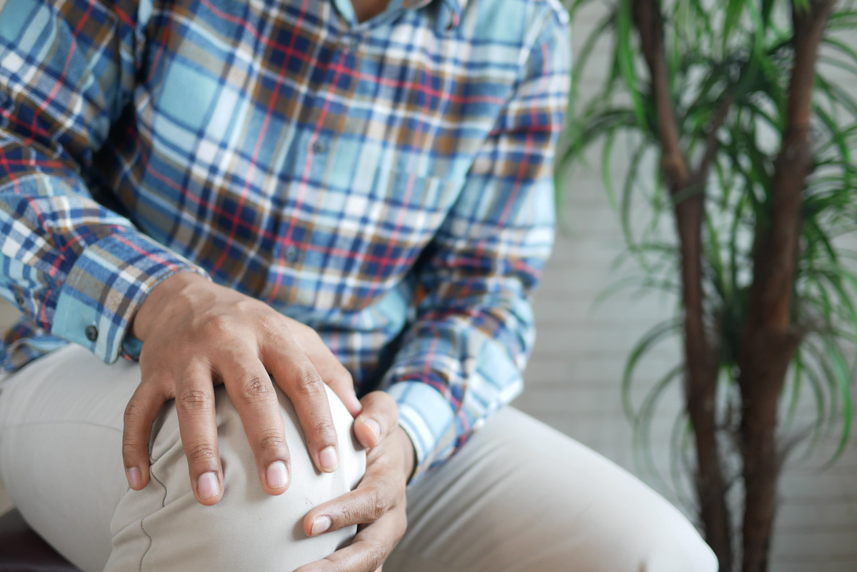 A man grabs his knee in pain