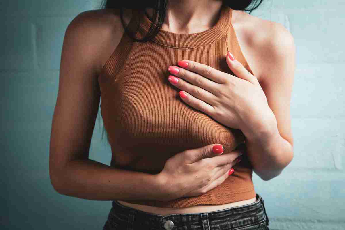 A young woman holds her chest