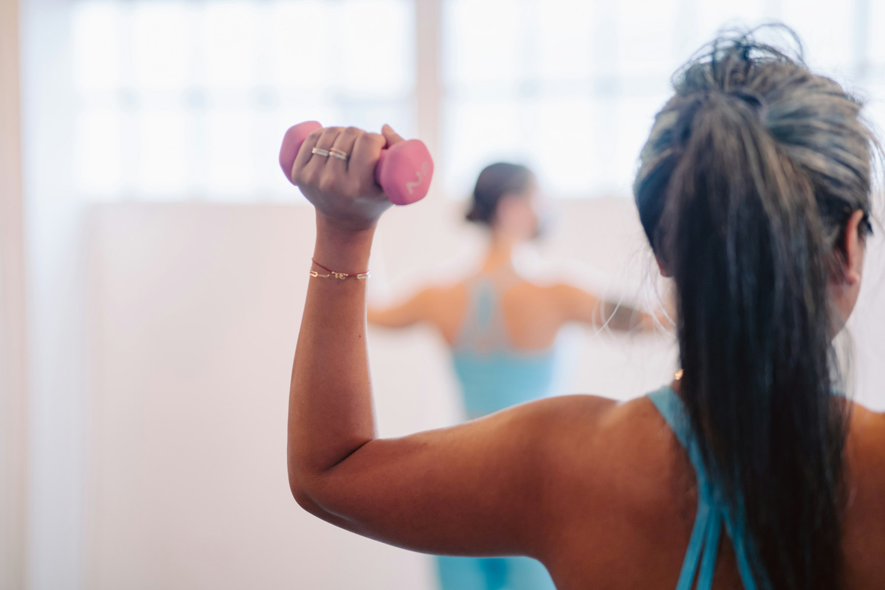 Woman works out with back to photographer