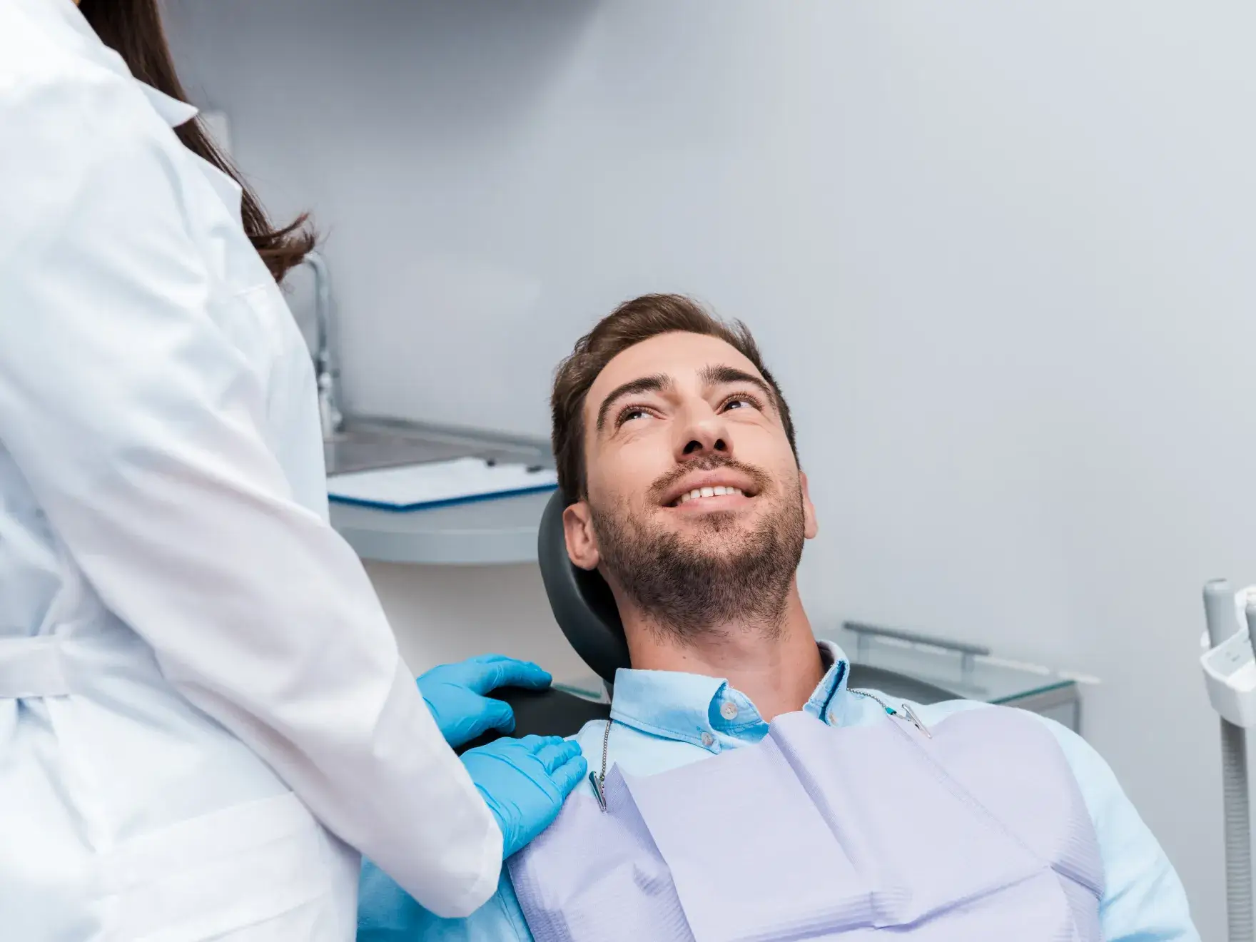 A man sitting in a dentist's chair with a smile on his face.