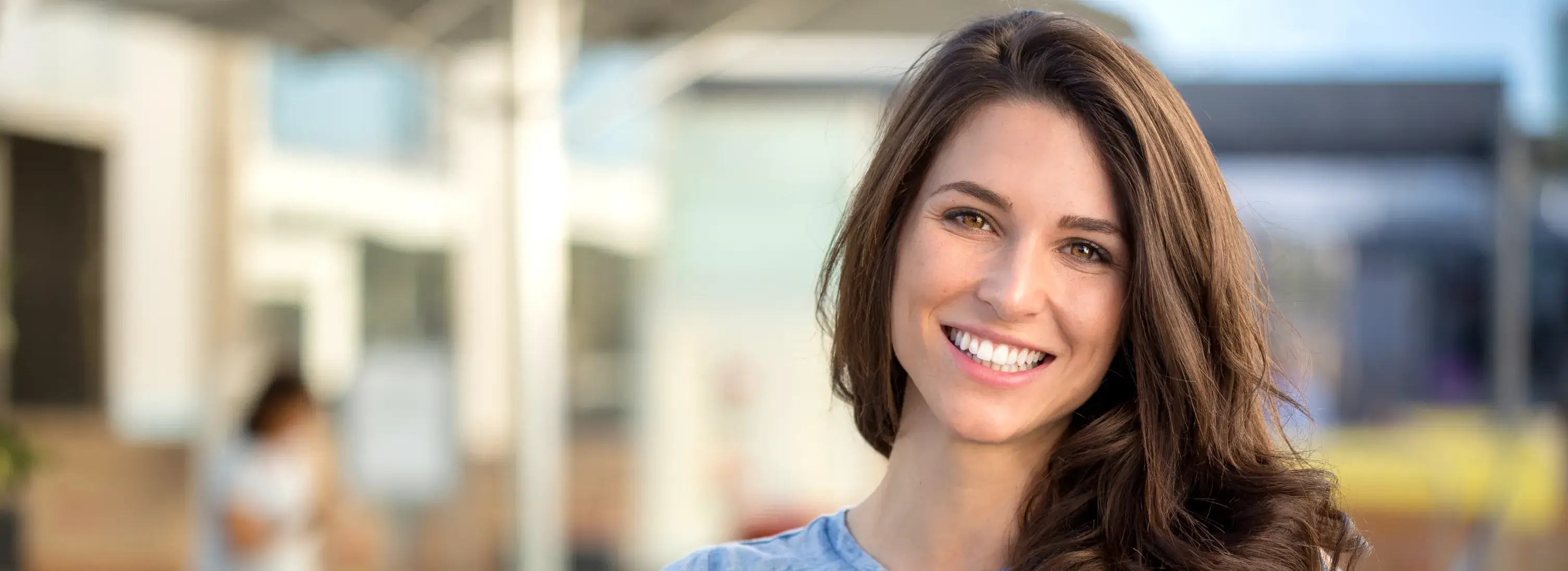 A woman with long brown hair smiling at the camera.