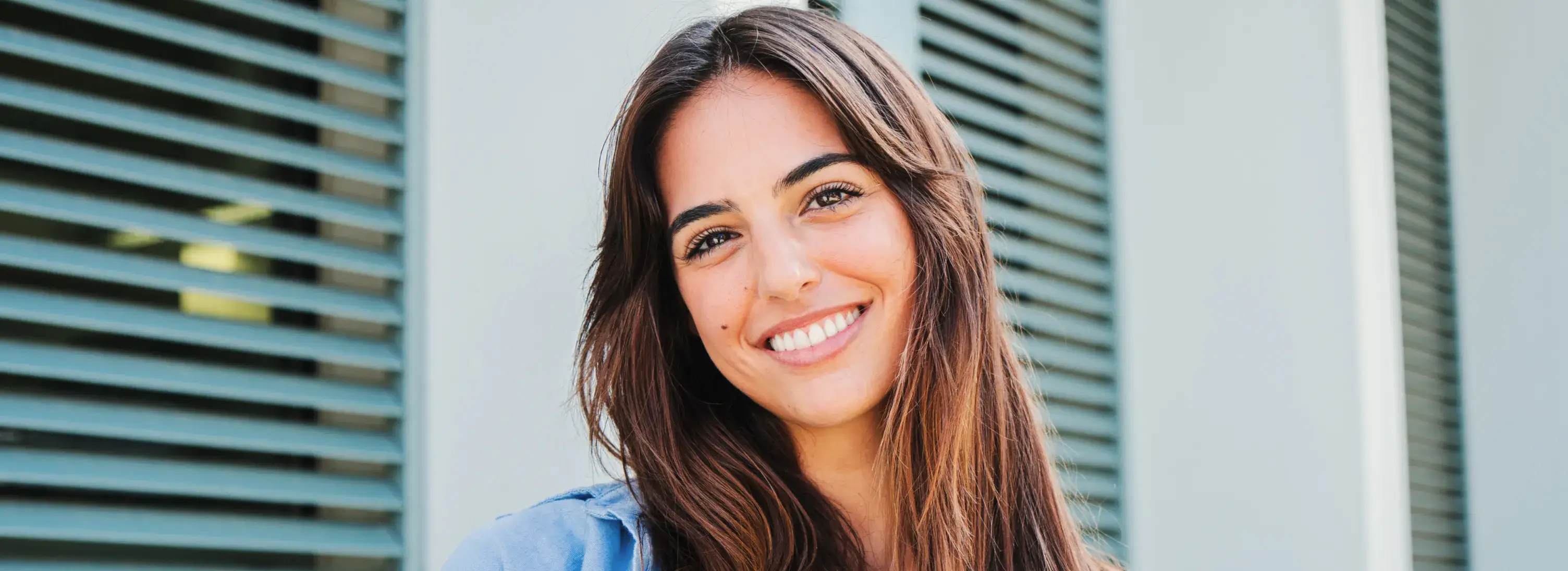 A woman with long brown hair smiling for the camera.