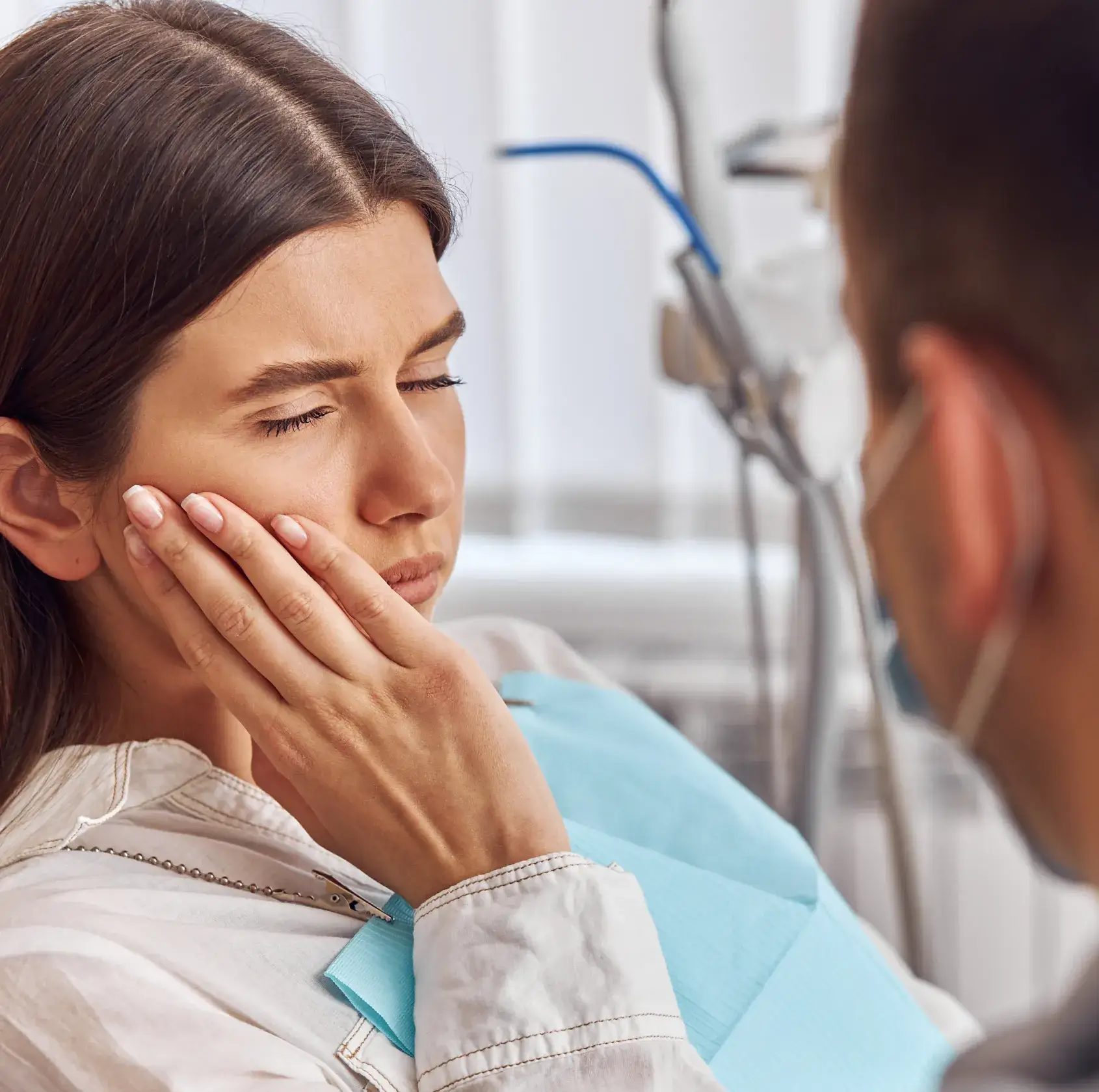 A woman with her hand on her face next to a man.