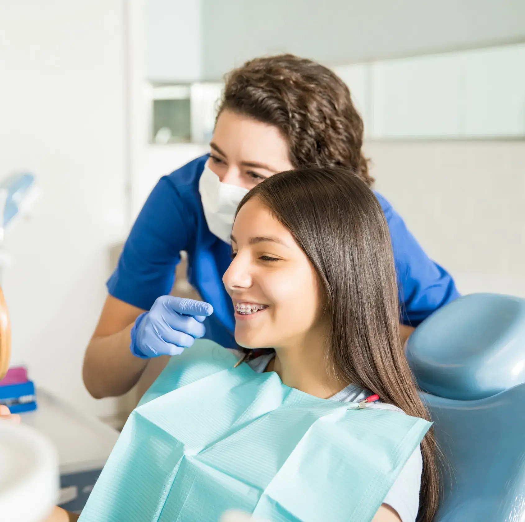 A young girl getting her teeth checked by a dentist.