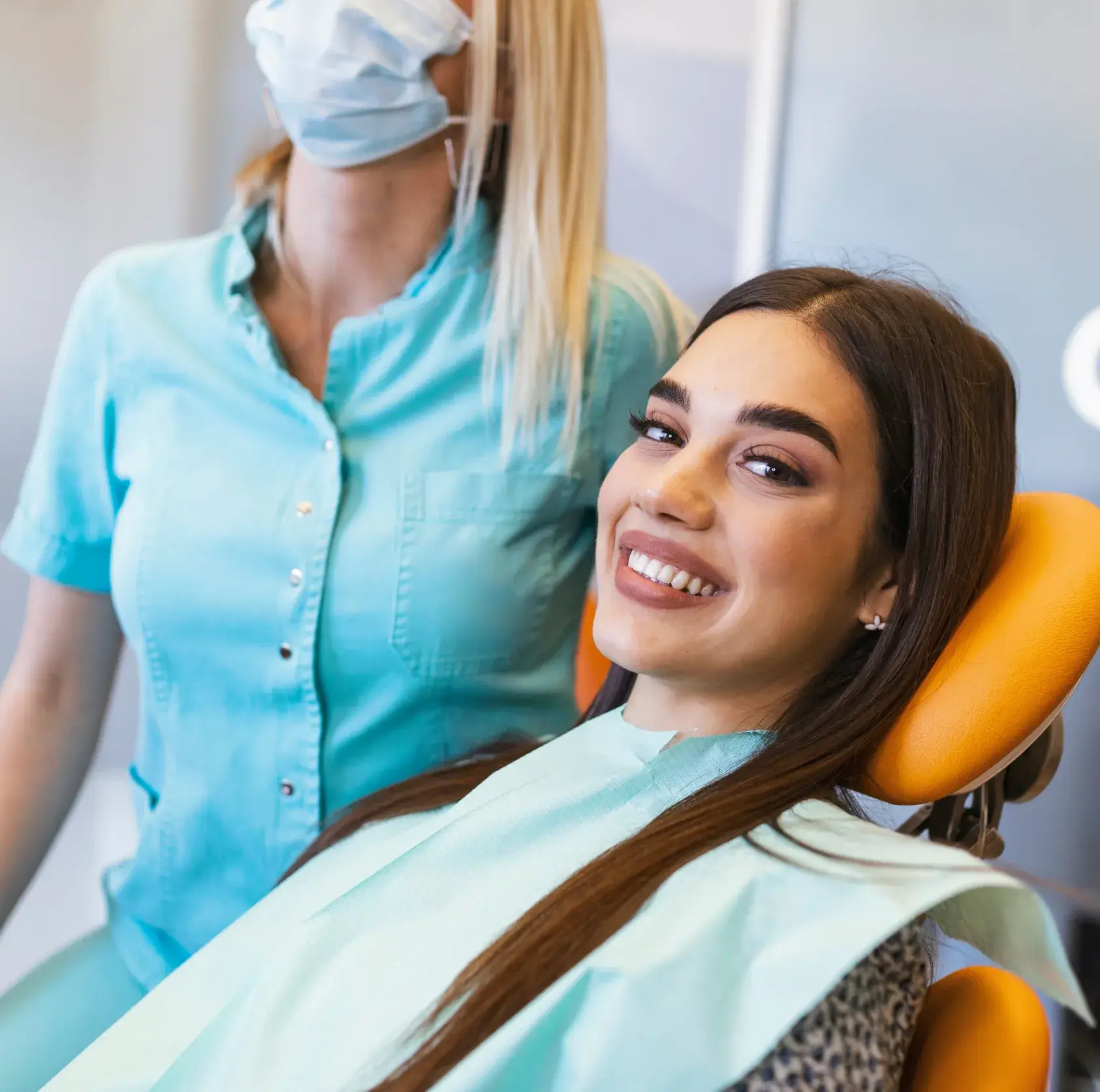 A woman sitting in a dental chair smiling.