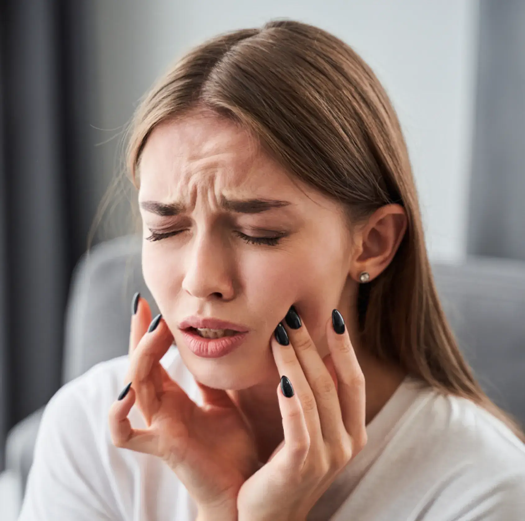 A woman holding her hand to her face.