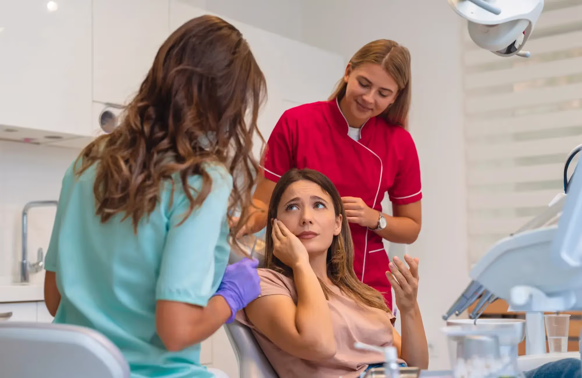 A woman sitting in a chair in a dentist's office.