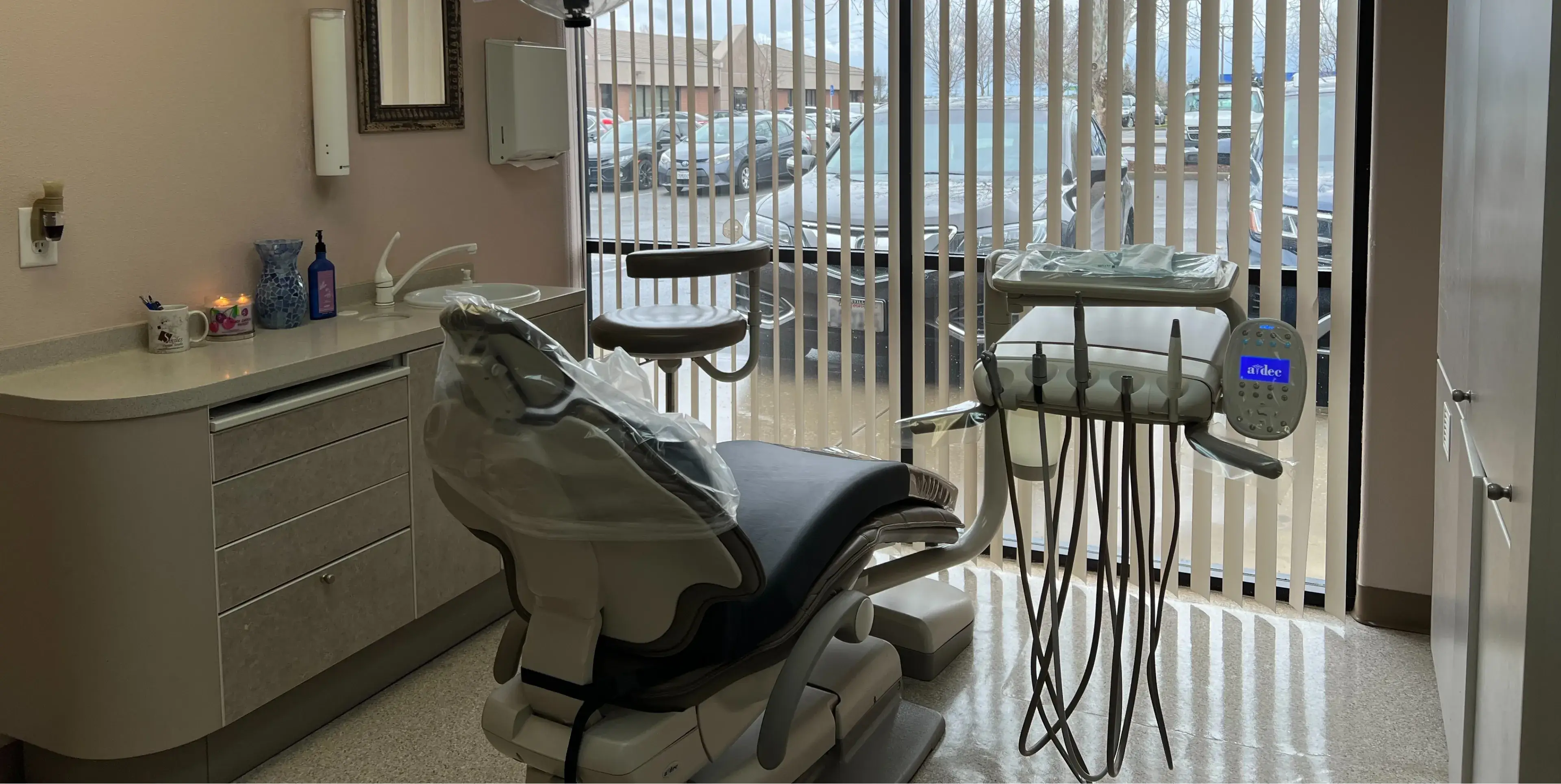 A dentist chair in a room with a sliding glass door.