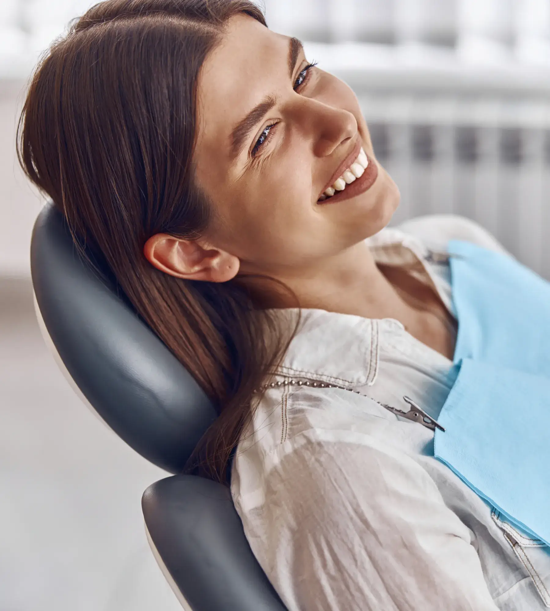 A woman smiling while sitting in a chair.