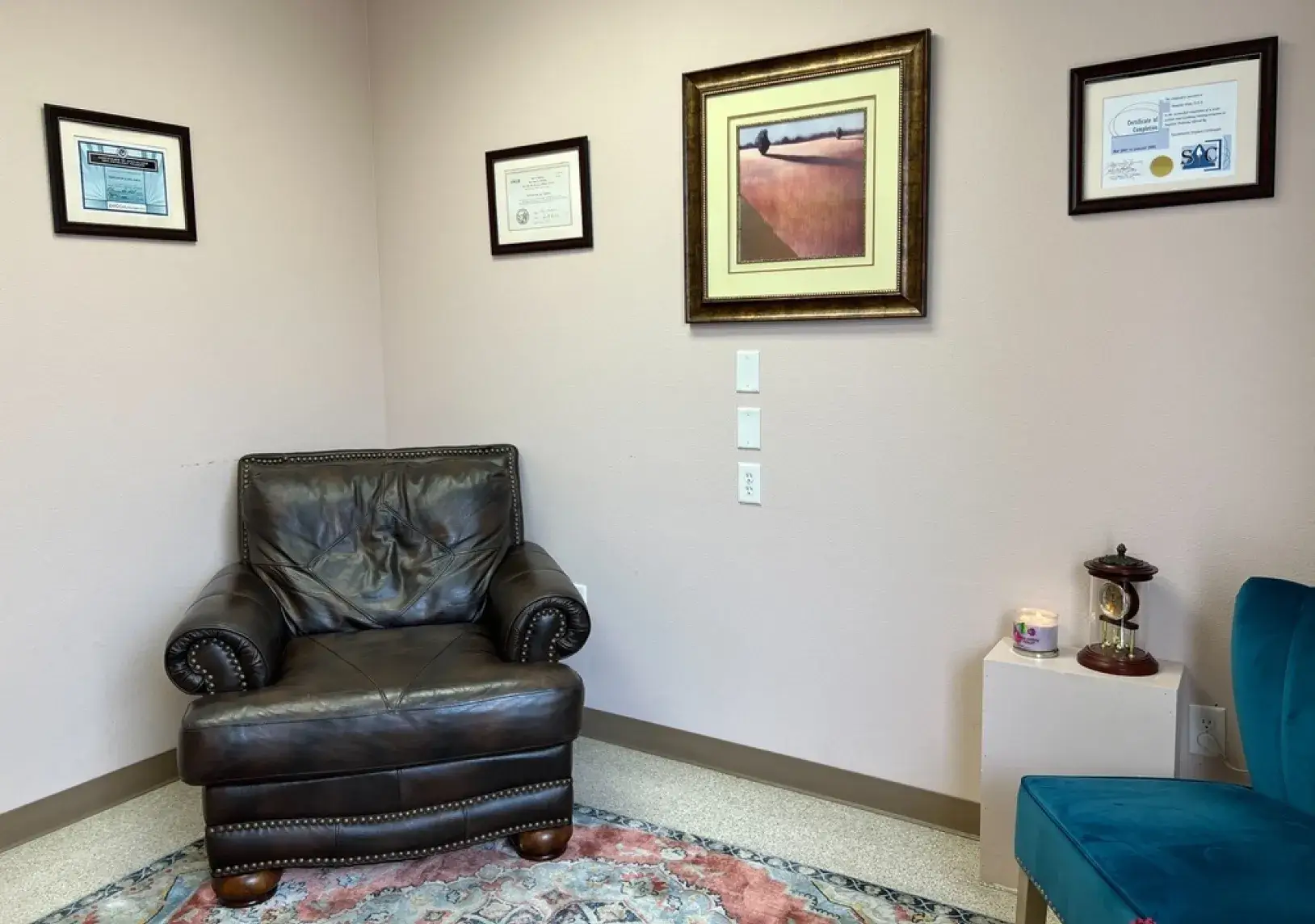 A room with a chair and pictures on the wall.