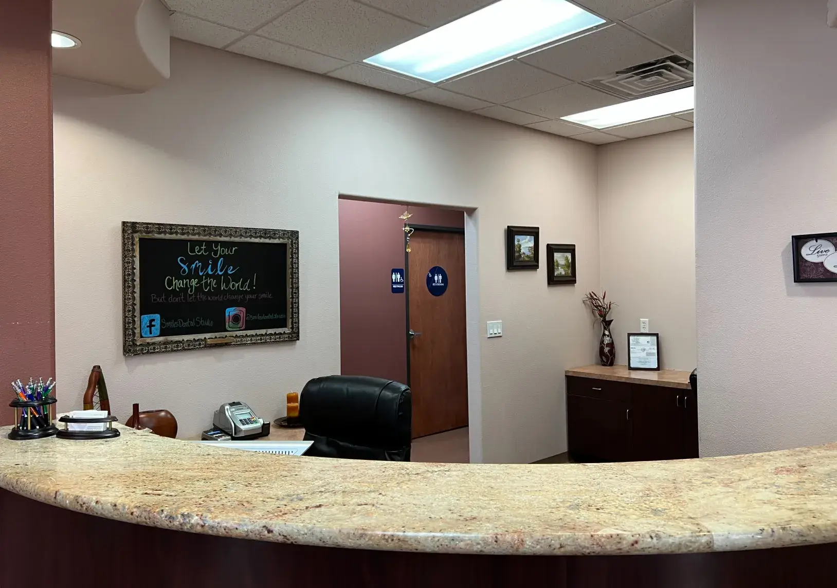 An office with a counter and a chalkboard on the wall.