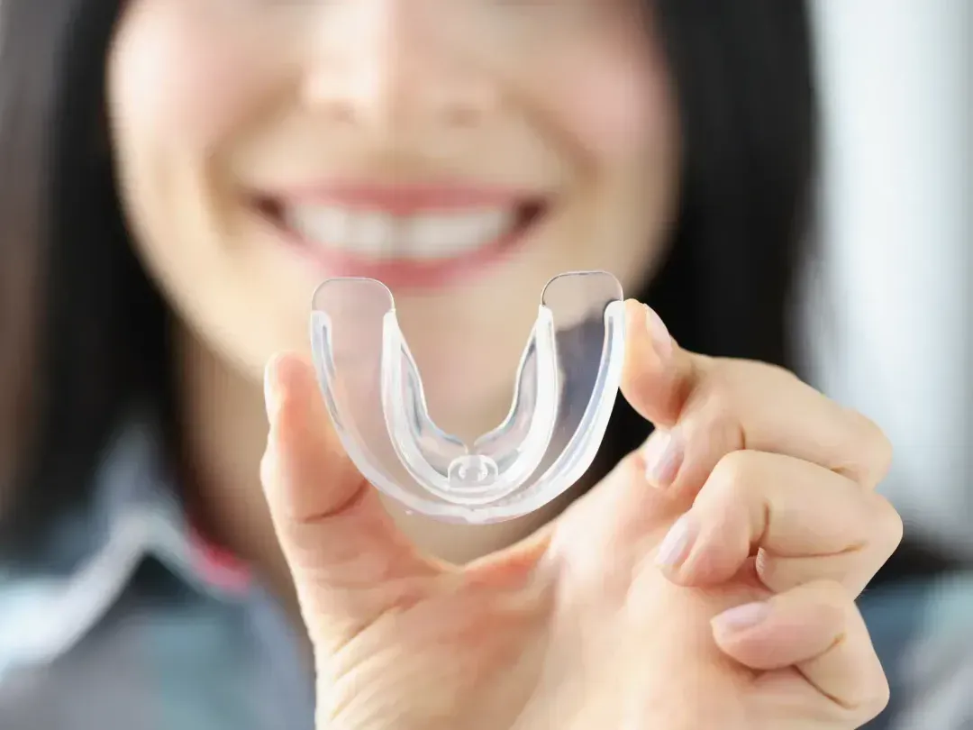 A woman holding a plastic object in her hand.