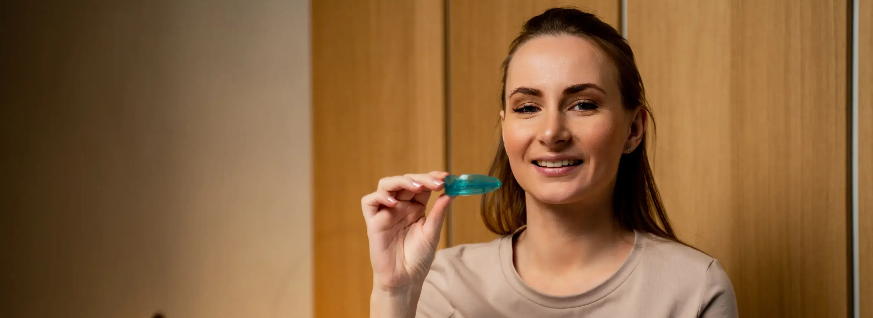 A woman holding a toothbrush in her right hand.