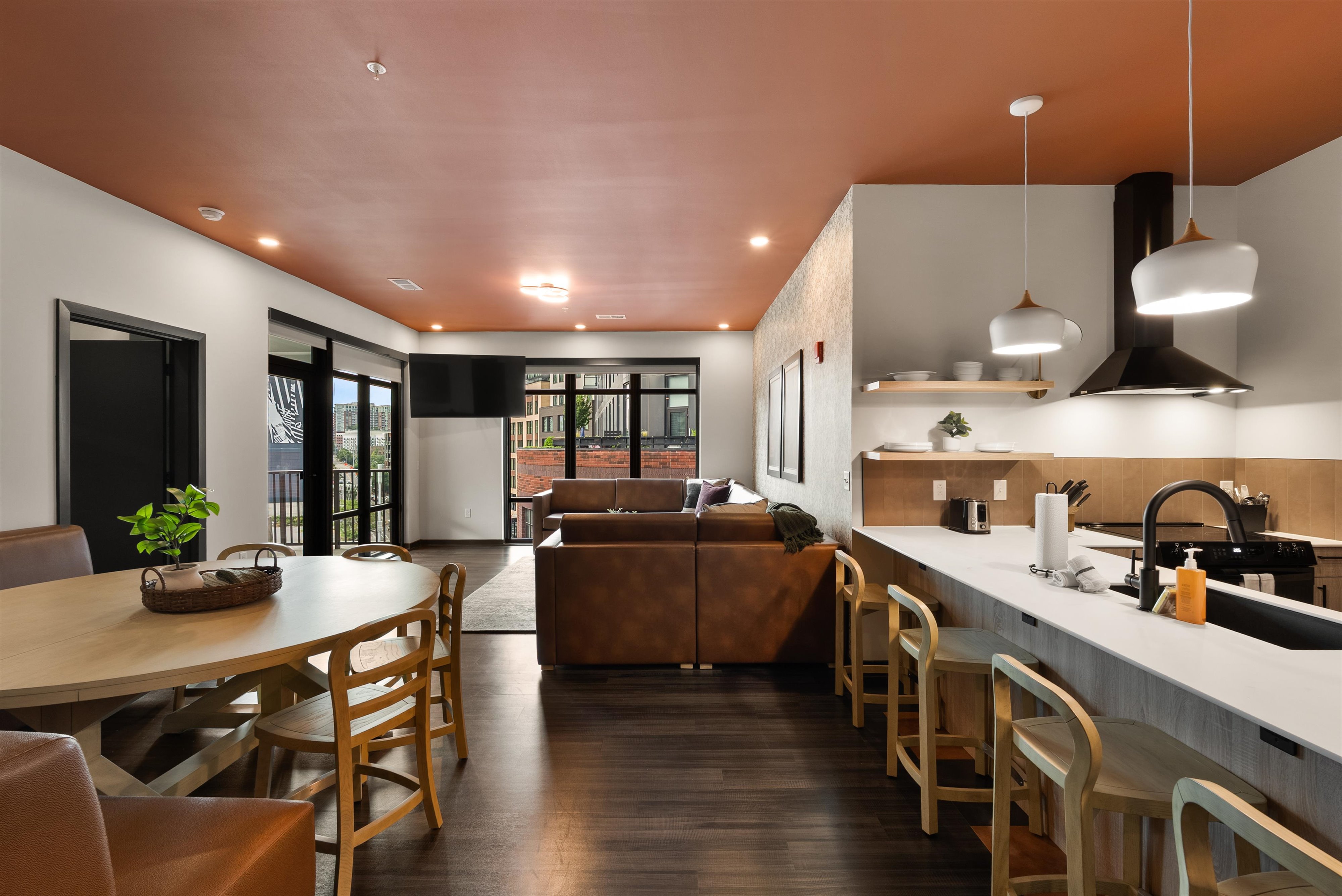 Common area with kitchen and leather sofa at The Quinley boutique hotel in The Gulch, Nashville